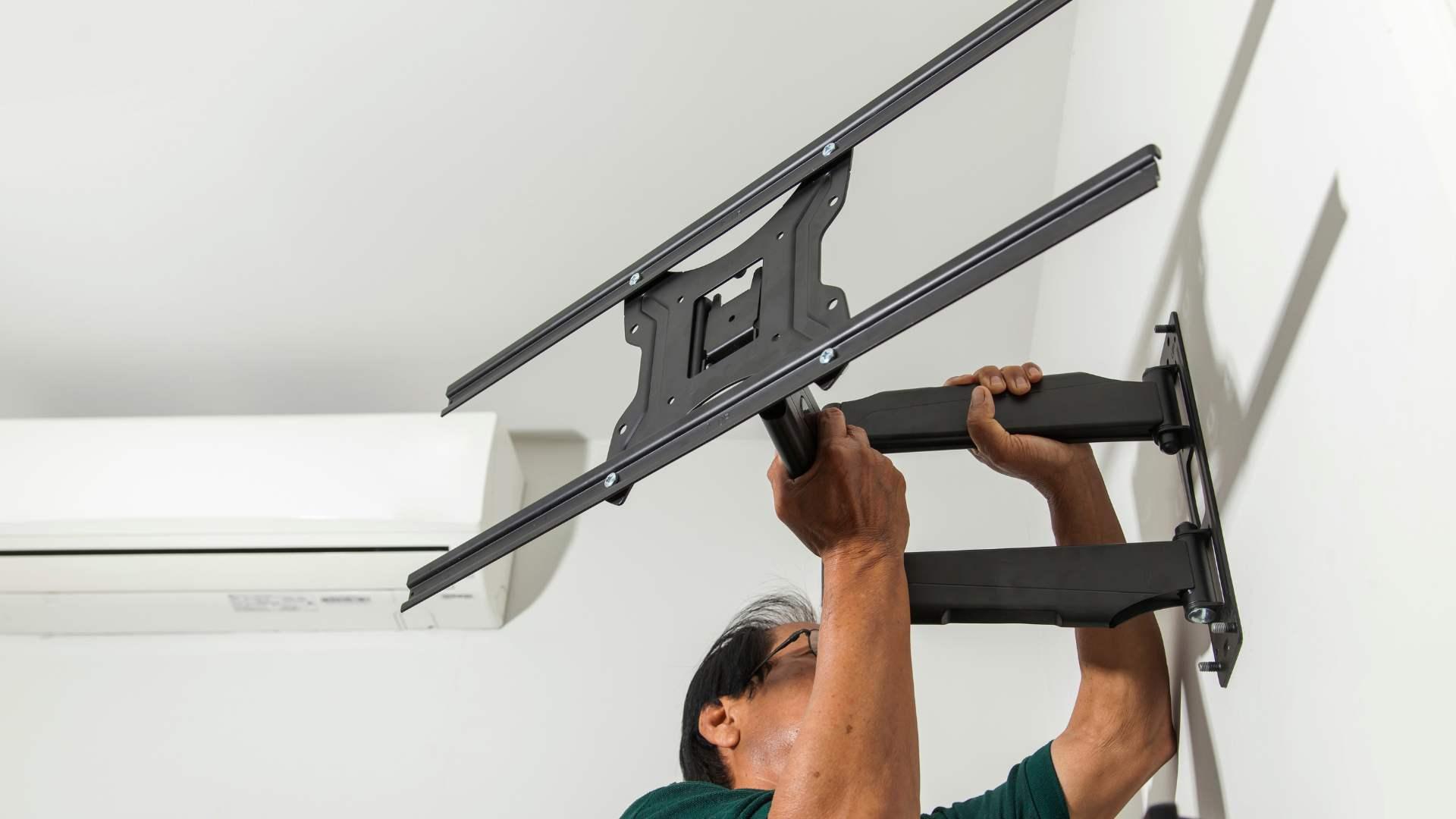 Handyman mounting a TV and performing home maintenance