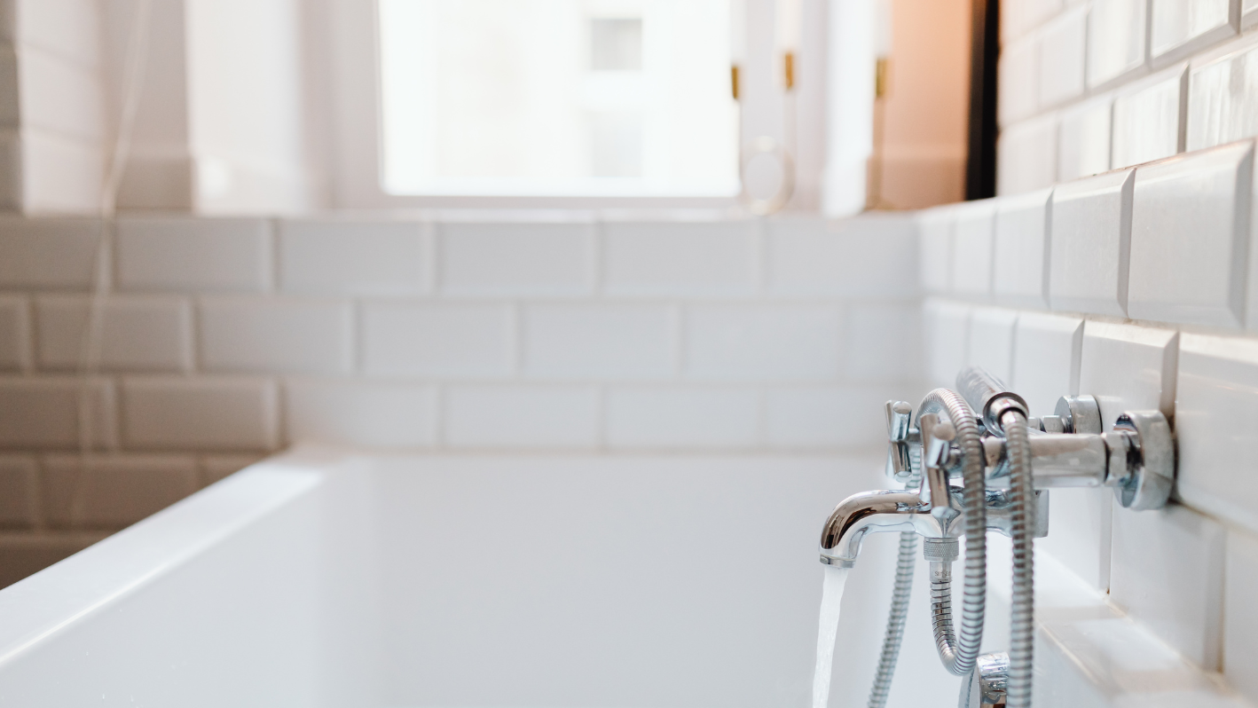 A white bath tub sitting next to a window